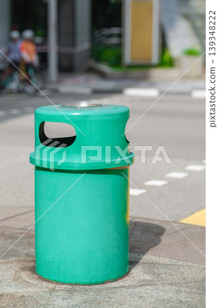Green street trash bin on urban sidewalk Green street trash bin on urban sidewalk 139348222