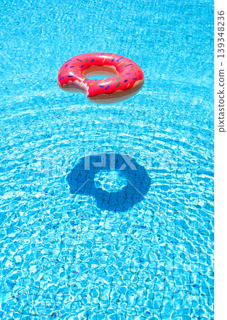 Pink donut inflatable floating in pool with shadow summer minimal concept Pink donut inflatable floating in pool with shadow summer minimal concept 139348236