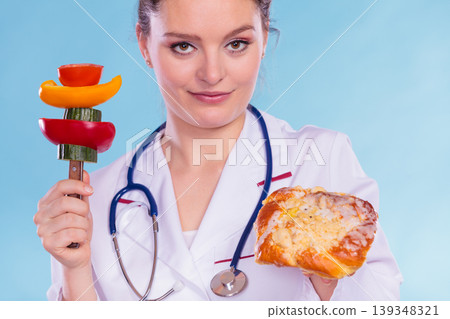 Dietitian with sweet roll bun and vegetables. Dietitian with sweet roll bun and vegetables. 139348321