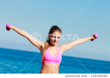 Fit woman training with dumbbells 139348360