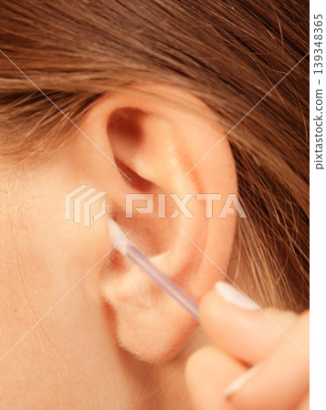 Woman cleaning ear with cotton swabs closeup Woman cleaning ear with cotton swabs closeup 139348365