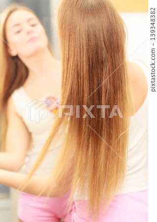 Woman taking care of her long hair applying cosmetic oil 139348382