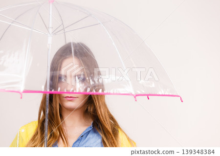 Woman wearing waterproof coat holding umbrella 139348384
