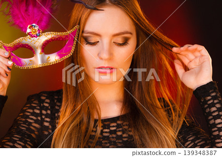 Woman holds carnival mask closeup Woman holds carnival mask closeup 139348387