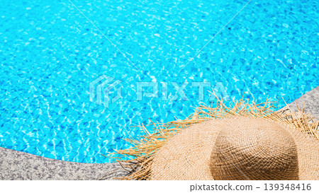 Straw summer hat by blue swimming pool water top view tropical vacation background Straw summer hat by blue swimming pool water top view tropical vacation background 139348416