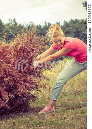 Woman removing pulling dead tree Woman removing pulling dead tree 139348578
