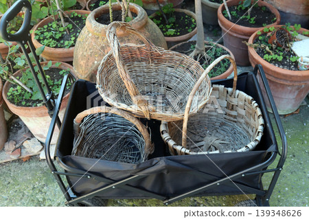 Garden cart carrying traditional wicker baskets in outdoor setting 139348626