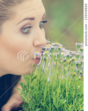 Woman smelling flowers Woman smelling flowers 139348689