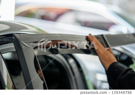 A car wrapping specialist applies a polyurethane film to the car. Detailer PPF 139348786