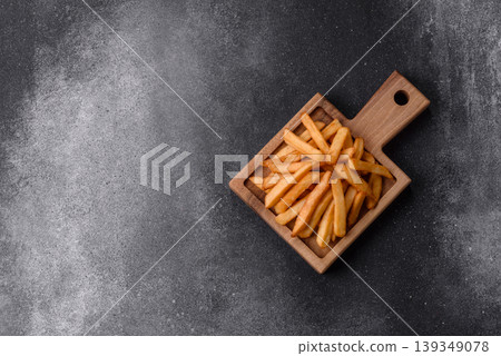 French fries, a salty, crispy, homemade snack with spices. French fries on a black background French fries, a salty, crispy, homemade snack with spices. French fries on a black background 139349078