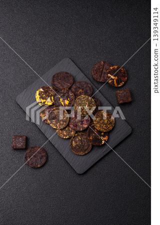 Organic Chinese green pu-erh tea with various herbs in round bricks. Chinese pu-erh tea Organic Chinese green pu-erh tea with various herbs in round bricks. Chinese pu-erh tea 139349114