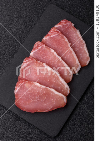 Smoked or dry cured meat slices, pork or ham with salt and spices. Smoked meat slices Smoked or dry cured meat slices, pork or ham with salt and spices. Smoked meat slices 139349130