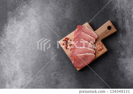 Smoked or dry cured meat slices, pork or ham with salt and spices. Smoked meat slices Smoked or dry cured meat slices, pork or ham with salt and spices. Smoked meat slices 139349131