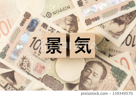 A block with the word "Economy" written on it and lots of 10,000 yen bills. A block with the word "Economy" written on it and lots of 10,000 yen bills. 139349570
