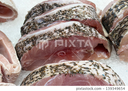 Raw fish body cuts representing seafood preparation, fishmongery and market freshness. Raw fish body cuts representing seafood preparation, fishmongery and market freshness. 139349654
