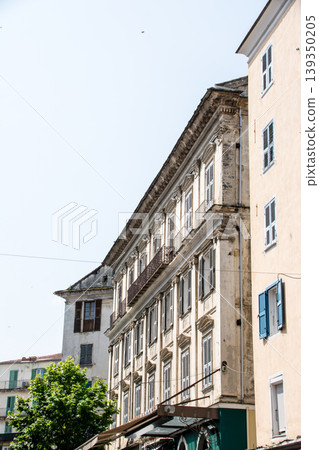A building with cream-colored walls bathed in bright sunlight on the French island of Corsica in the Mediterranean Sea. A building with cream-colored walls bathed in bright sunlight on the French island of Corsica in the Mediterranean Sea. 139350205