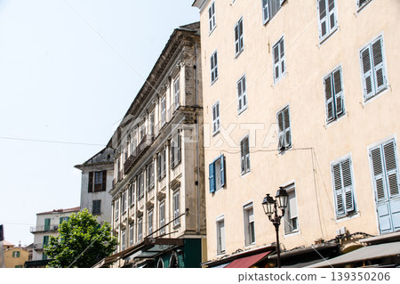 A building with cream-colored walls bathed in bright sunlight on the French island of Corsica in the Mediterranean Sea. A building with cream-colored walls bathed in bright sunlight on the French island of Corsica in the Mediterranean Sea. 139350206