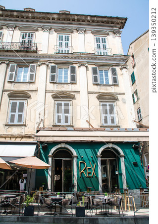 A building with cream-colored walls bathed in bright sunlight on the French island of Corsica in the Mediterranean Sea. 139350212
