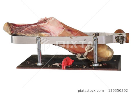 Serrano ham leg resting on wooden holder Serrano ham leg resting on wooden holder 139350292