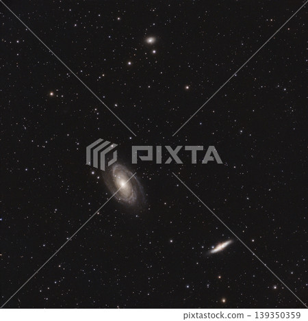Multiple spiral and elliptical galaxies are visible against a dark night sky filled with numerous stars of varying brightness. 139350359