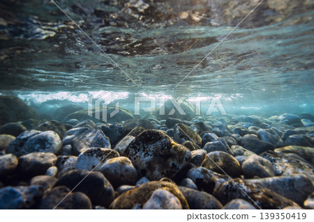 Underwater ocean with stones sea bottom, sun rays in clear water. Underwater ocean with stones sea bottom, sun rays in clear water. 139350419