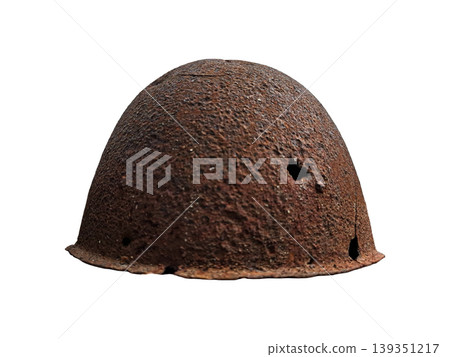 The image shows a soldier's helmet that has rusted with age. It has visible bullet holes. The helmet stands out against a white background, highlighting its worn condition. The image shows a soldier's helmet that has rusted with age. It has visible bullet holes. The helmet stands out against a white background, highlighting its worn condition. 139351217