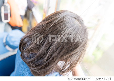 一位年輕的日本女孩正望著電車窗外。 139351741