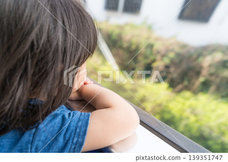 A young Japanese girl looking out the window of a streetcar. A young Japanese girl looking out the window of a streetcar. 139351747