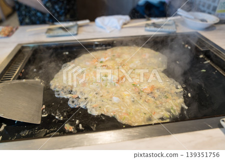 Seafood monjayaki cooked on a hot plate Seafood monjayaki cooked on a hot plate 139351756