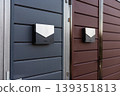 Modern mailboxes mounted on contrasting colored gates for secure deliveries 139351813
