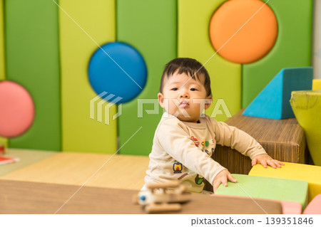 A Japanese baby boy playing in a colorful kids' room. A Japanese baby boy playing in a colorful kids' room. 139351846