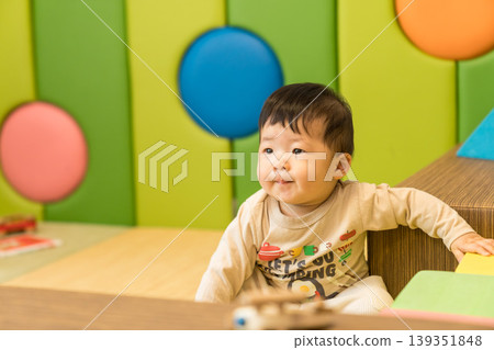 A Japanese baby boy playing in a colorful kids' room. A Japanese baby boy playing in a colorful kids' room. 139351848