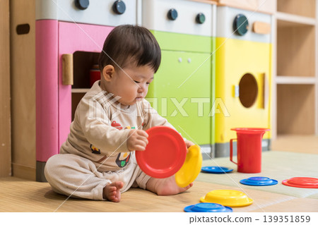 A Japanese baby boy playing in a colorful kids' room. A Japanese baby boy playing in a colorful kids' room. 139351859