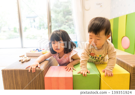 Japanese brother and sister playing in the apartment building's kids' room. Japanese brother and sister playing in the apartment building's kids' room. 139351924