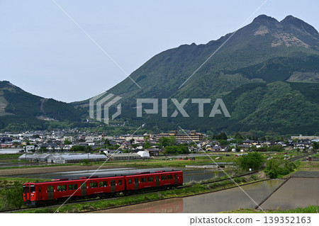A local train running with Mount Yufu in the background. A local train running with Mount Yufu in the background. 139352163