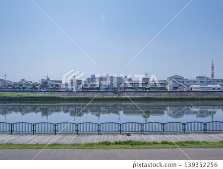 住宅區的景色倒映在平靜的河面上。 139352256