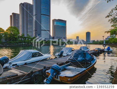 夕陽西下,碼頭和摩天大樓熠熠生輝。 夕陽西下,碼頭和摩天大樓熠熠生輝。 139352259