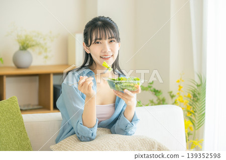 A young woman eating a salad A young woman eating a salad 139352598