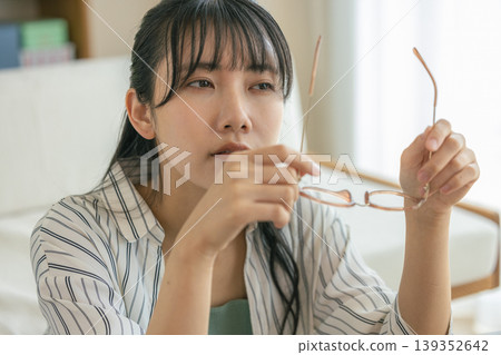 一名女子因眼睛疲勞而摘下眼鏡休息。 139352642