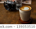 Wooden desktop pour-over latte art with heart-shaped latte art and camera 139353510