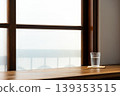 Wooden lattice window view, frosted glass, ceramic coffee cup and clear water glass. 139353515