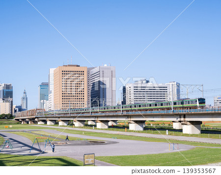 [Tokaido Main Line] Local train crossing the Tamagawa River on a holiday morning. 139353567