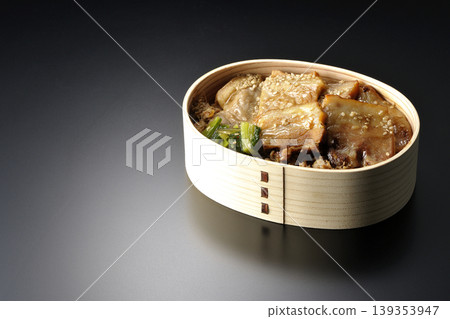 A photo of a grilled pork bento box against a black background. 139353947