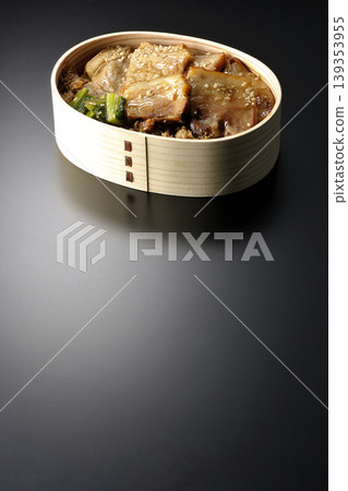一張黑色背景上的烤豬肉便當盒照片。 一張黑色背景上的烤豬肉便當盒照片。 139353955