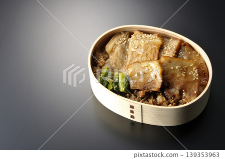 一張黑色背景上的烤豬肉便當盒照片。 139353963