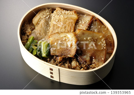 A photo of a grilled pork bento box against a black background. A photo of a grilled pork bento box against a black background. 139353965