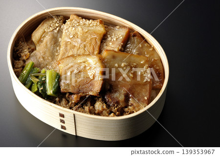 一張黑色背景上的烤豬肉便當盒照片。 一張黑色背景上的烤豬肉便當盒照片。 139353967