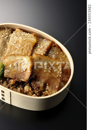 一張黑色背景上的烤豬肉便當盒照片。 一張黑色背景上的烤豬肉便當盒照片。 139353981