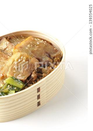 A photo of a grilled pork bento box against a white background. A photo of a grilled pork bento box against a white background. 139354025