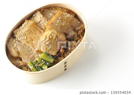 A photo of a grilled pork bento box against a white background. A photo of a grilled pork bento box against a white background. 139354034